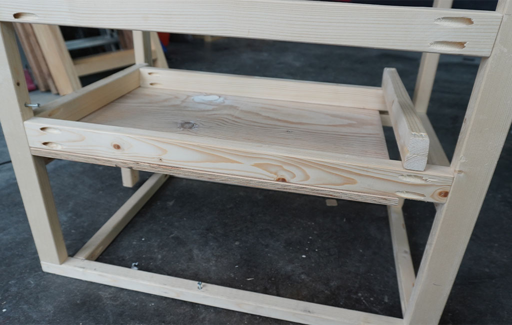 Wooden frame with inserted shelf, pocket hole drillings clearly visible.