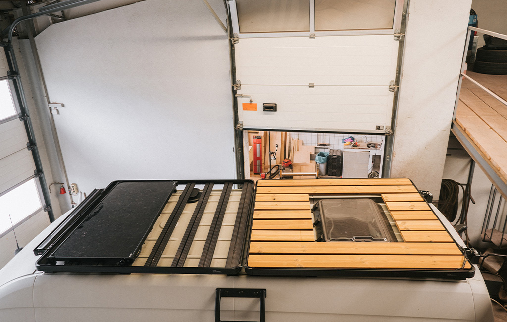 Camper-Dach mit halbfertig montierten Holzlatten und Dachluke in der Mitte.