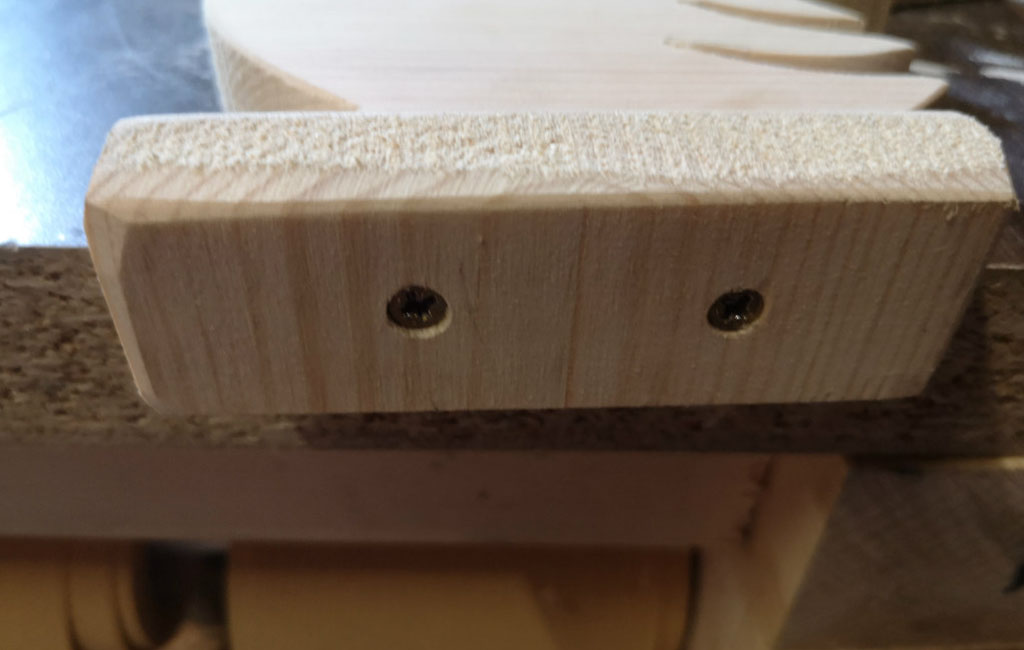 Holzblock von der Unterseite mit zwei gebohrten Löchern.