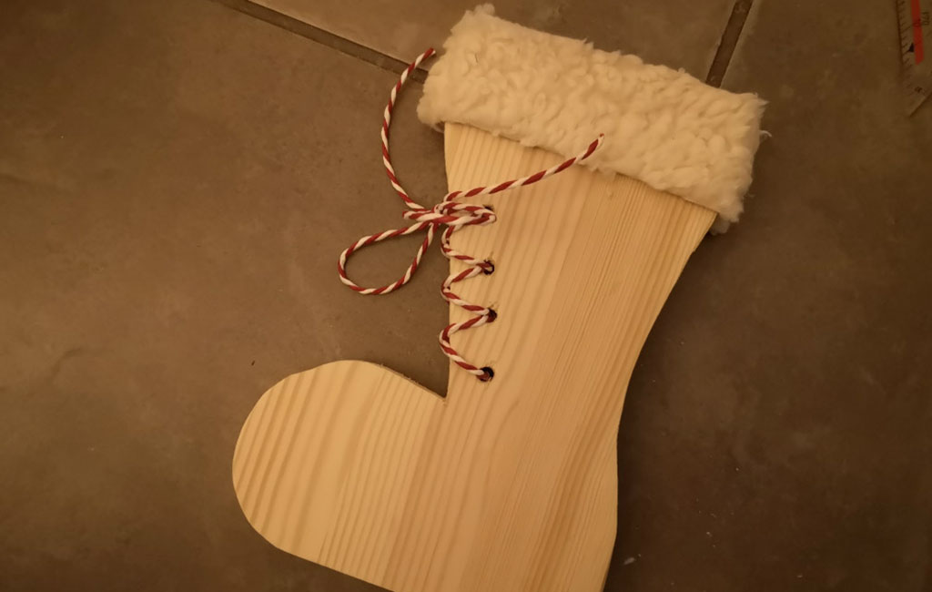 Holzstiefel-Dekoration mit rot-weißen Schnürsenkeln und weichem Schaft.