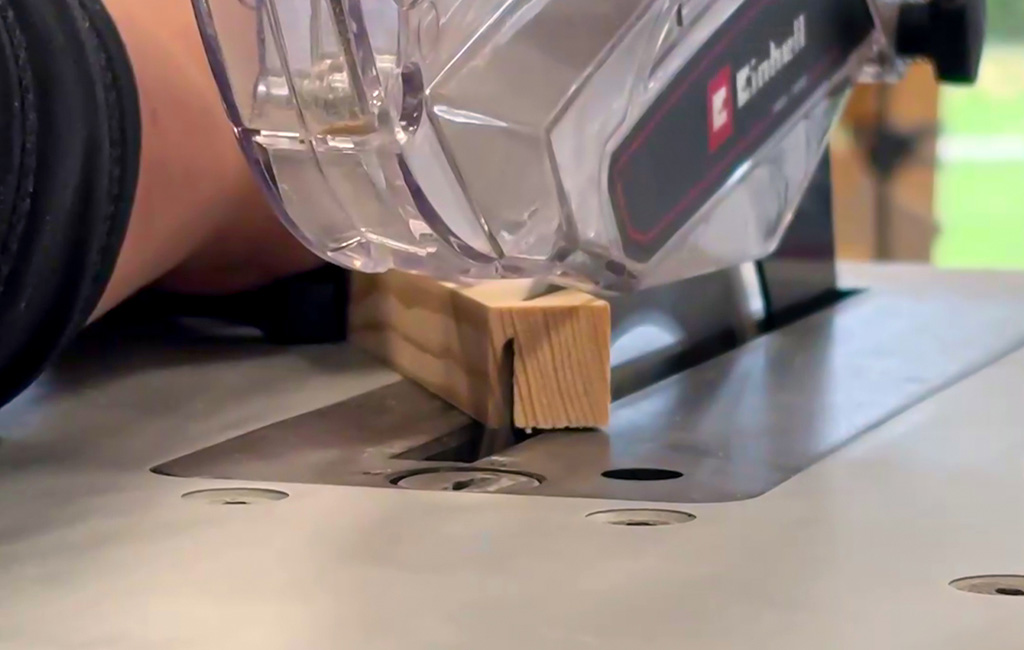 Nahaufnahme: Eine Einhell-Kreissäge schneidet ein Holzstück auf einer Werkbank.