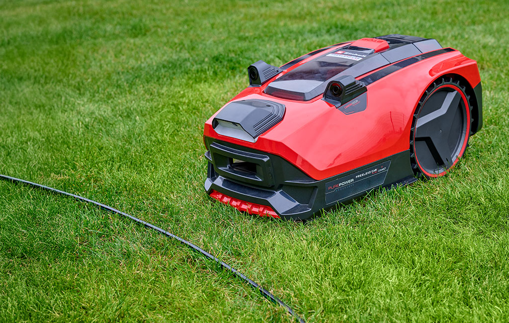 Der Einhell Mähroboter FREELEXO CAM fährt auf Rasen entlang eines Magnetbands.