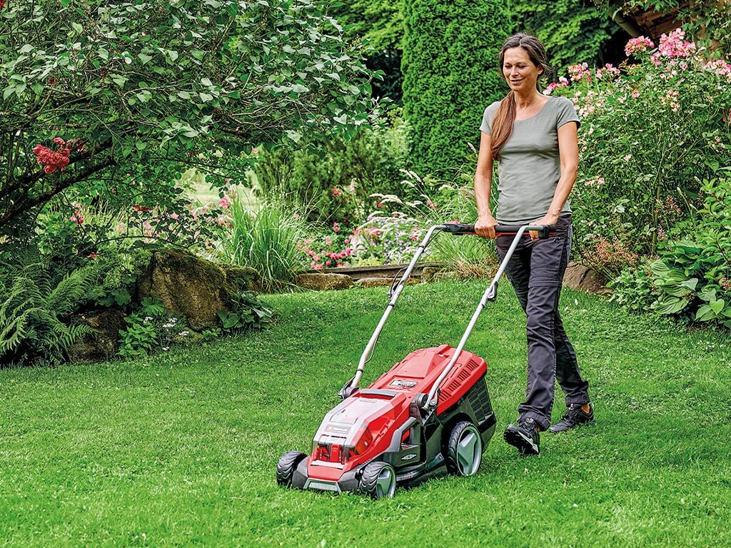 a woman mows the large garden