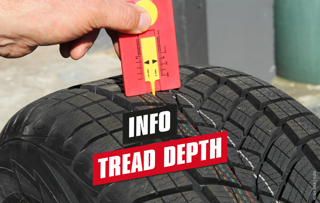 Someone is checking the tread of a car tyre | text: Info - tread depth