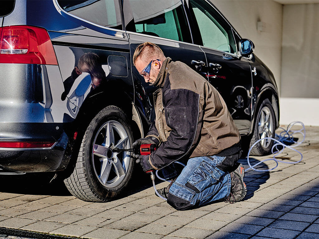 a man tightens the screws on the car