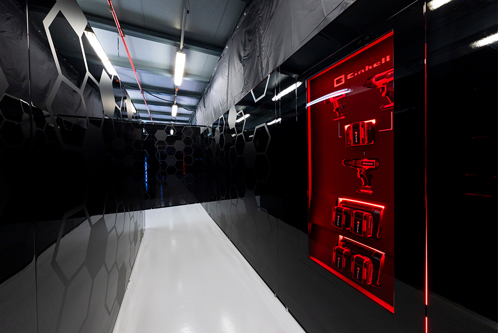 Area espositiva moderna con logo Einhell all’interno di un edificio.