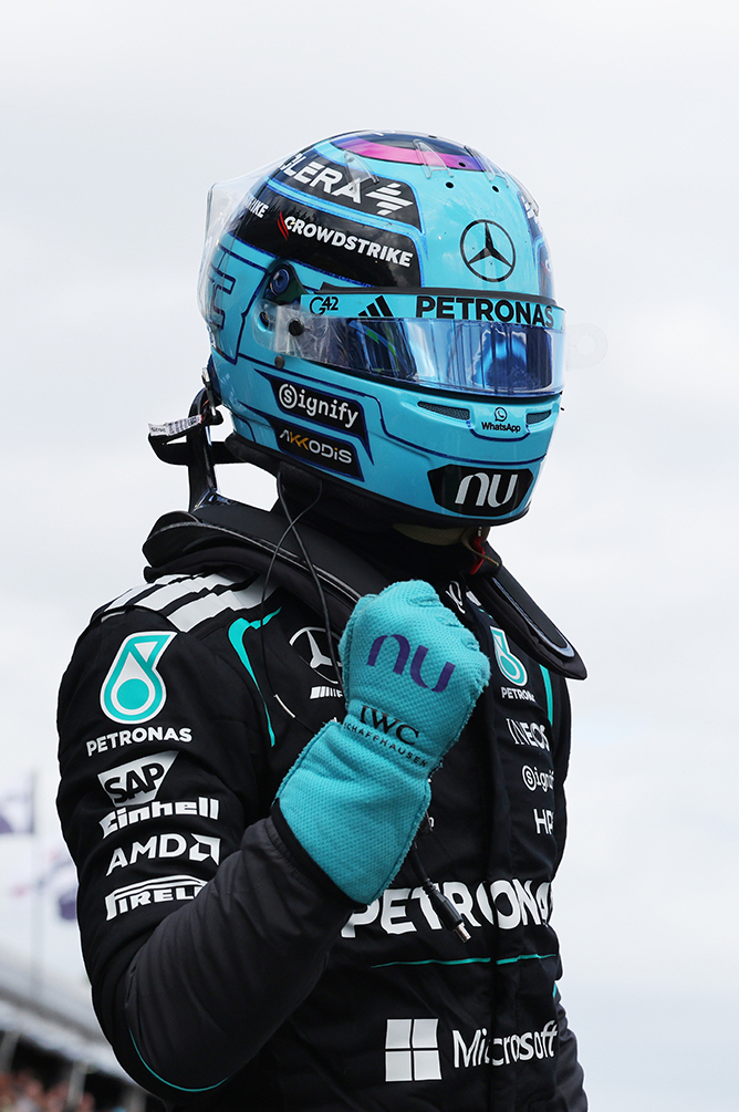 Pilota di Formula 1 con casco blu e tuta da gara sul circuito.