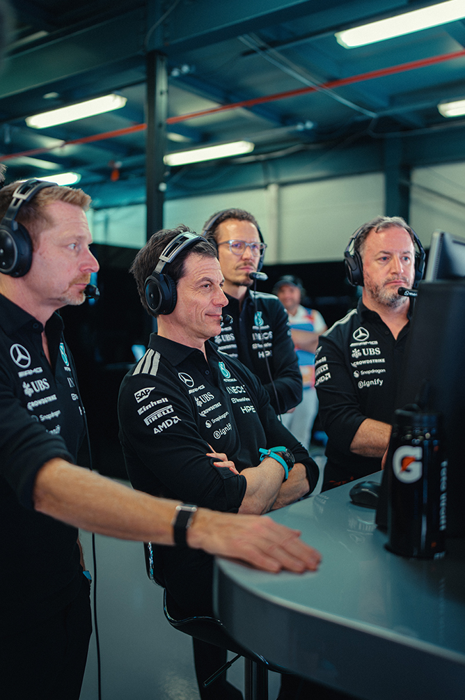 Membri del team di Formula 1 osservano la gara nella corsia dei box.