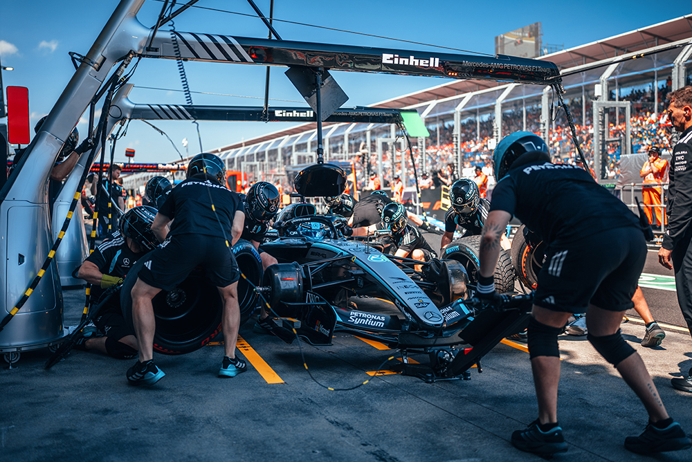 Team di Formula 1 che esegue un pit stop su una monoposto nella corsia dei box.