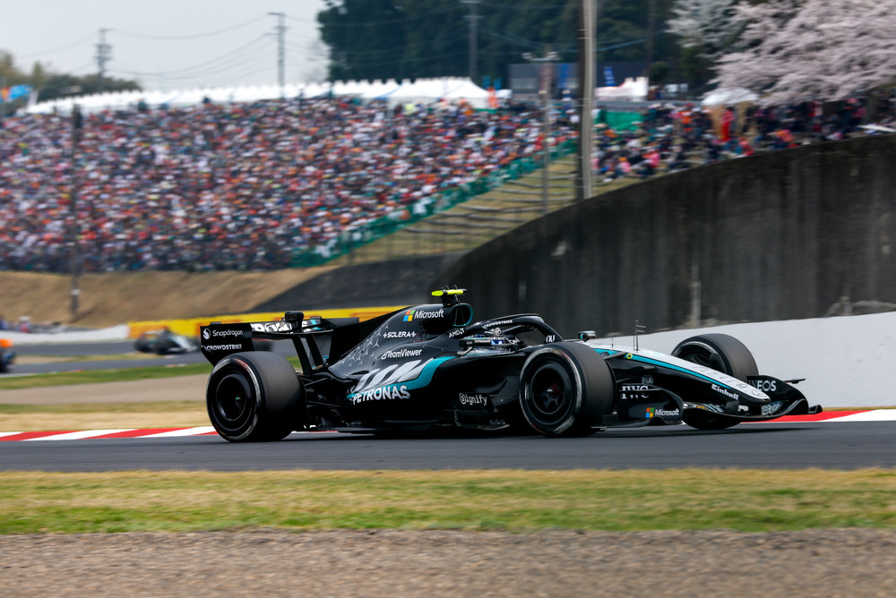 Voiture F1 Mercedes passant devant des tribunes pleines