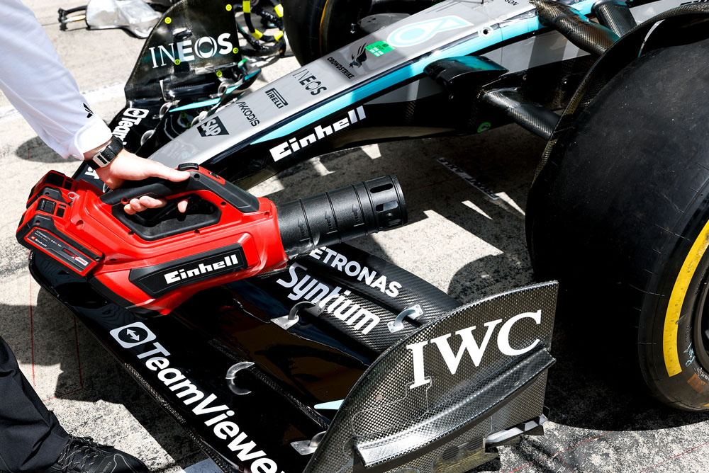Un souffleur Einhell est dirigé vers l’aileron avant d’une voiture de Formule 1.