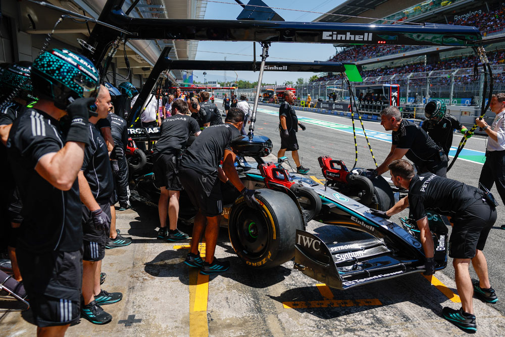 Une voiture de Formule 1 est poussée dans le garage.