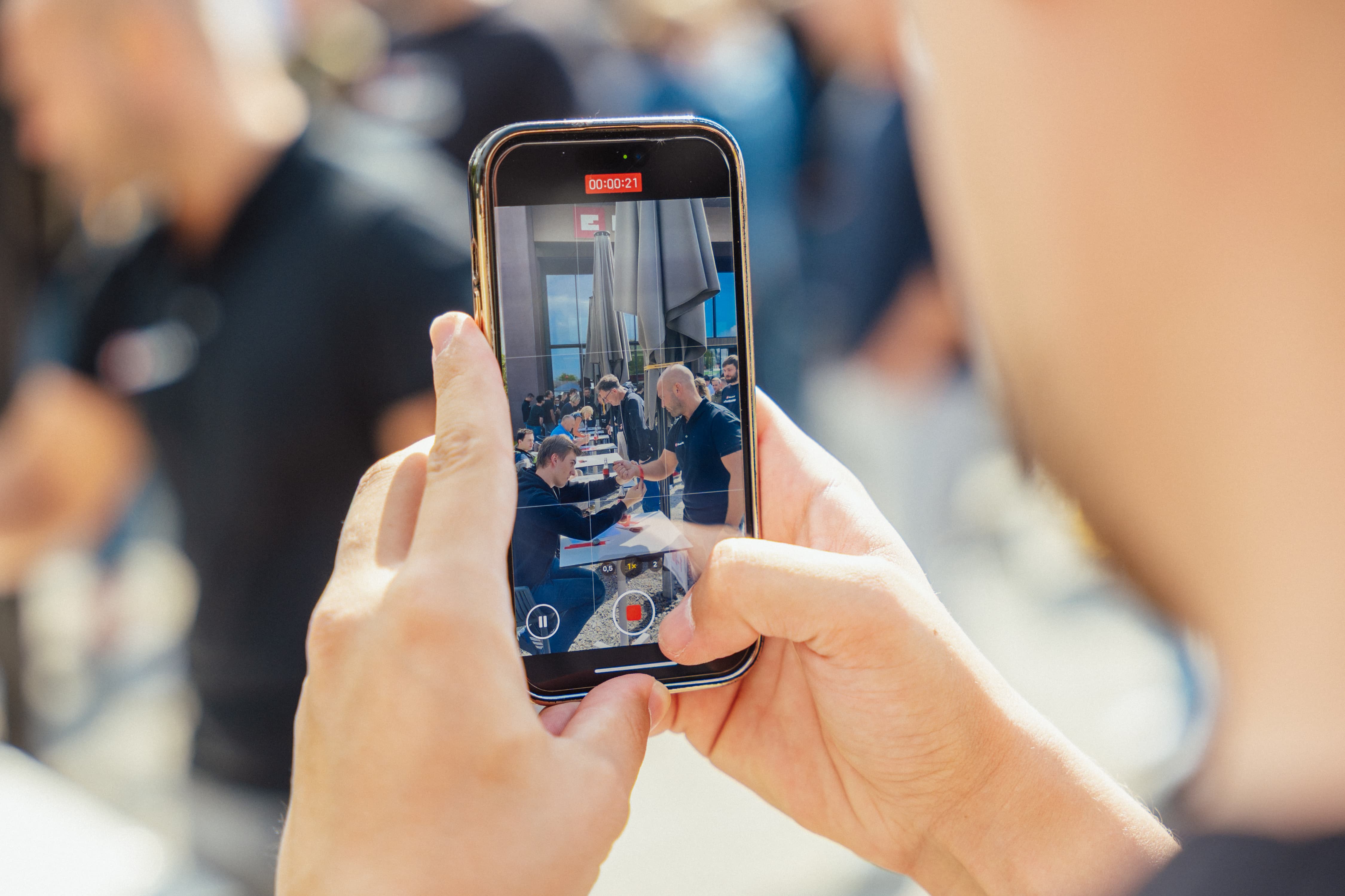 Nahaufnahme eines Smartphones, das eine Videoaufnahme vom Einhell-Event mit Händedruck zeigt.