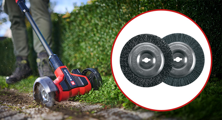 Ein Mann entfernt Unkraut zwischen Pflastersteinen mit einem Einhell Fugenreiniger; daneben sind zwei Ersatzbürsten aus Stahl und Nylon zu sehen.