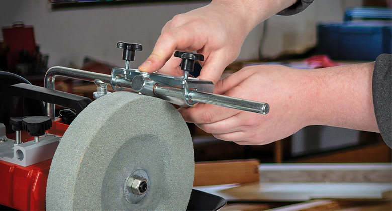 Hände justieren eine Vorrichtung an einem Einhell Nassschleifer.