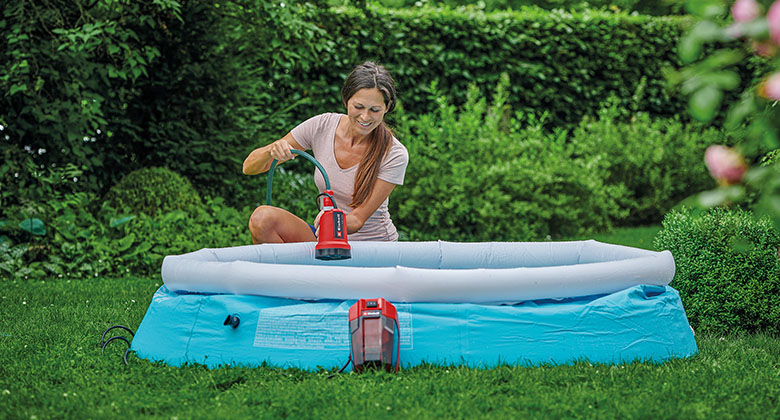 Eine Frau beim Auspumpen eines Pools mit Hilfe einer Akku-Klarwasserpumpe.