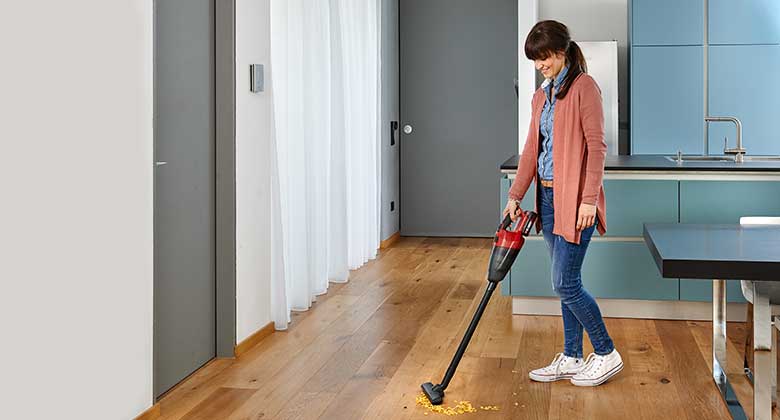 woman with a stick vacuum cleaner