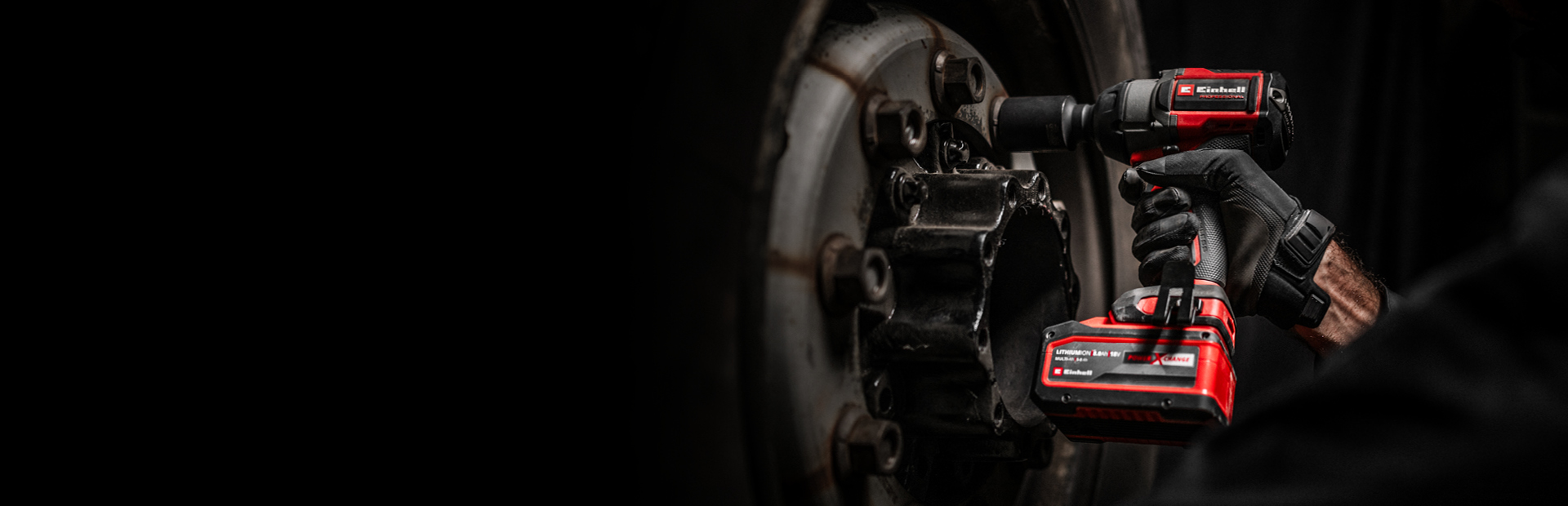 Close-up of a red cordless impact wrench being used on a wheel