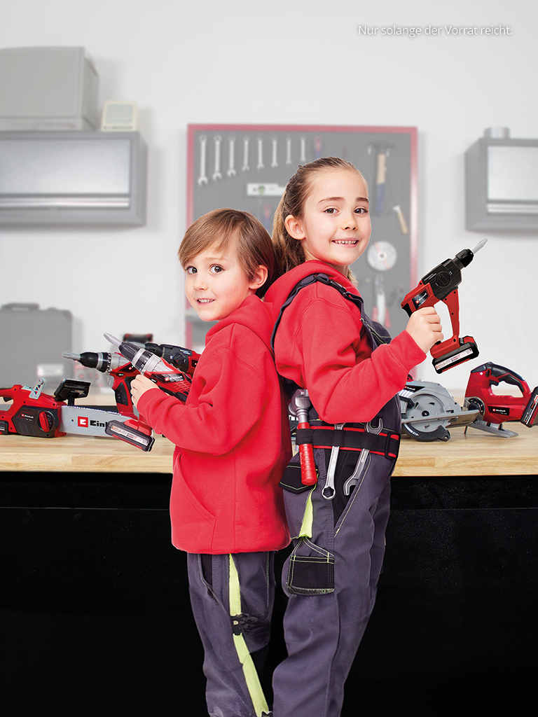 Aufnahme von zwei Kindern in Arbeitskleidung mit Spielzeugwerkzeugen in den Händen.